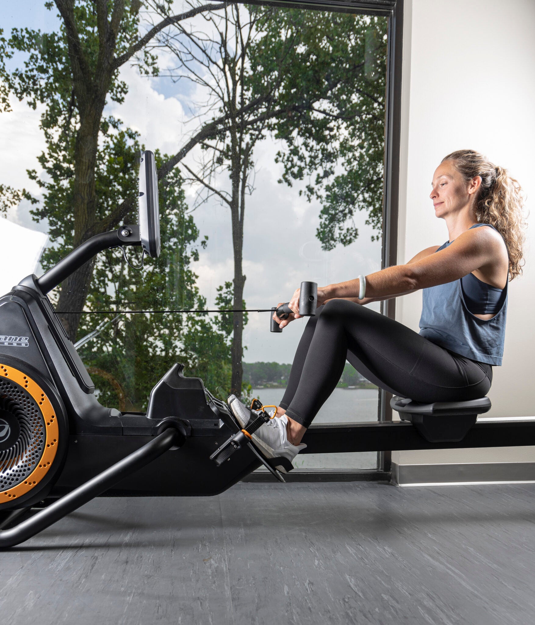 Octane Rō Rower Indoor Rowing Machine Woman Using Rower Side View. Octane Fitness