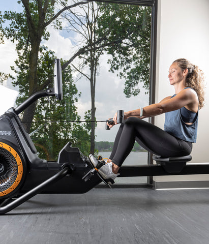 Octane Rō Rower Indoor Rowing Machine Woman Using Rower Side View. Octane Fitness